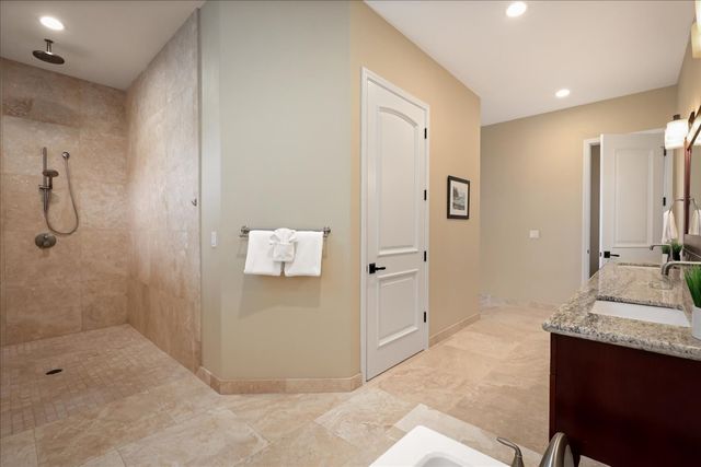 a bathroom with a granite countertop sink a mirror and shower
