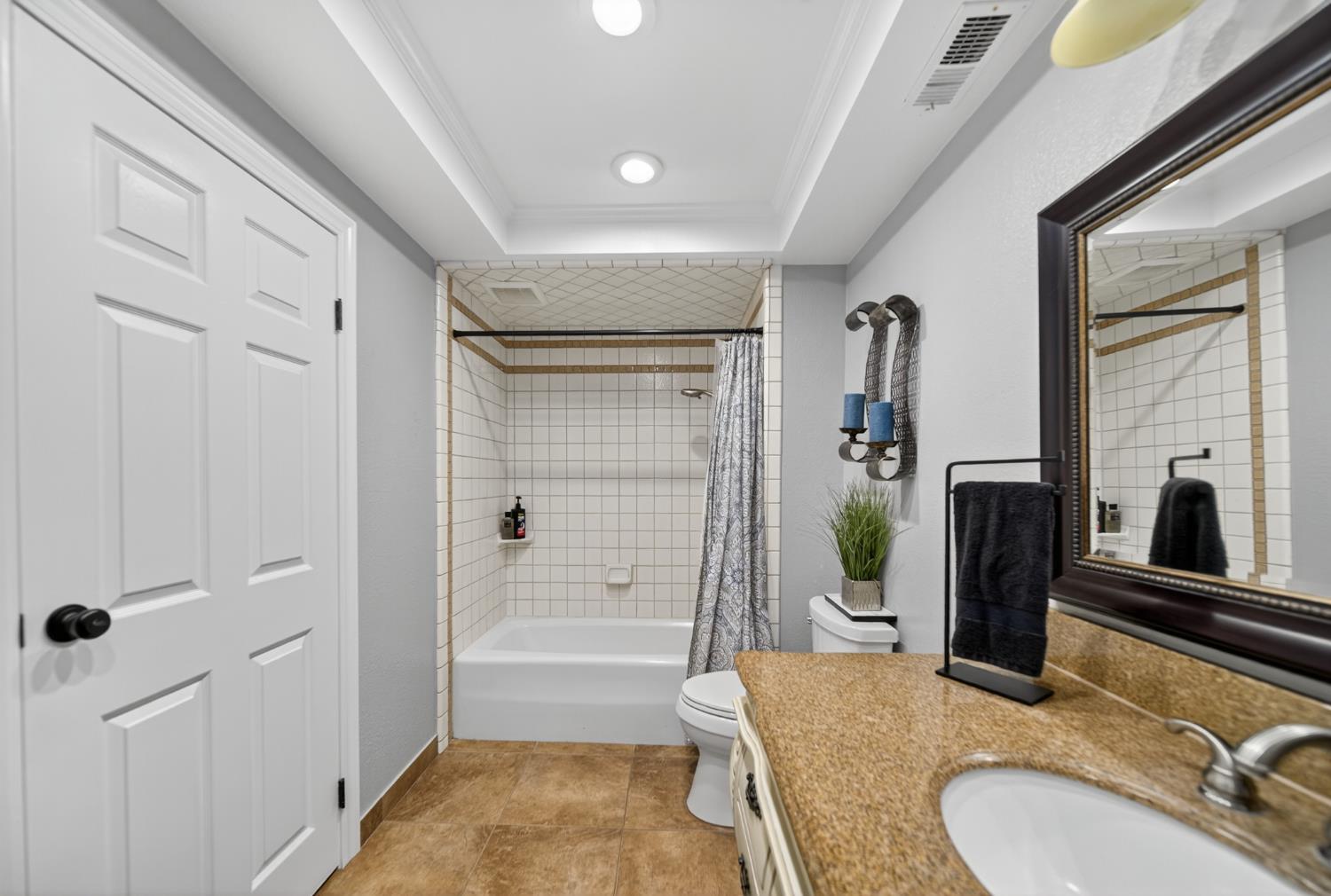 101 Mainberry Drive Madera, CA 93637 - Photo 23 of 40 a bathroom with a granite countertop sink a mirror a bathtub and shower