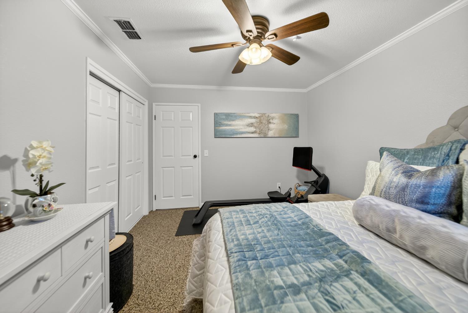 101 Mainberry Drive Madera, CA 93637 - Photo 25 of 40 a bedroom with a large bed and a chandelier