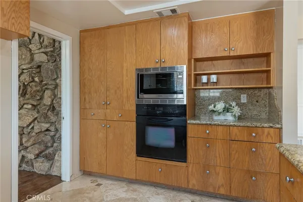 a kitchen with granite countertop a stove and a microwave oven