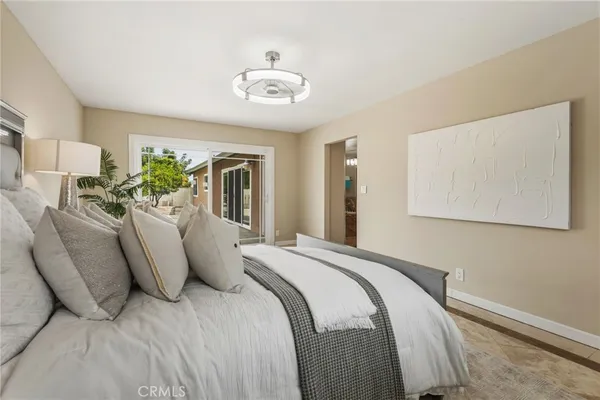 a spacious bedroom with a bed and a chandelier