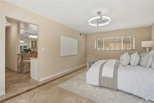 a bedroom with a large bed and chandelier