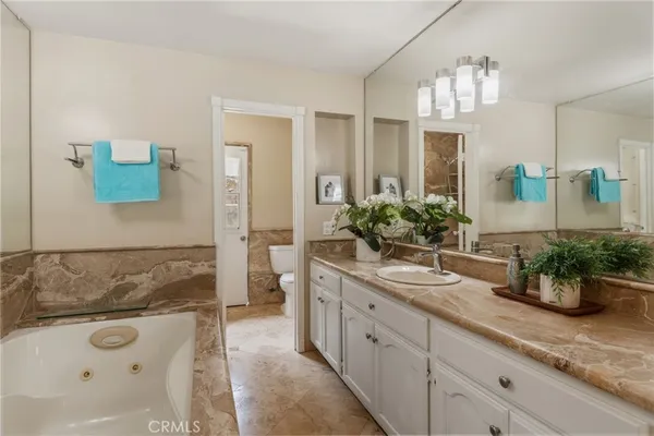 a bathroom with a tub sink and mirror