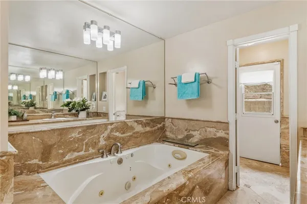 a bathroom with a bathtub a sink and a mirror