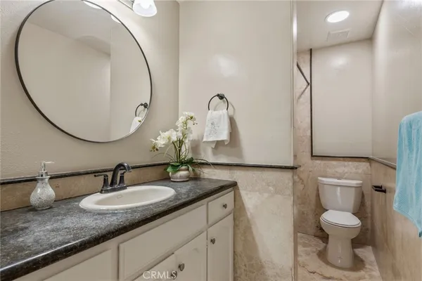 a bathroom with a granite countertop sink and a mirror