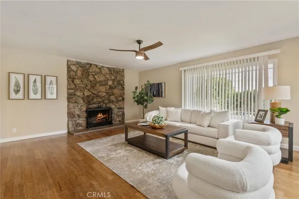 a living room with furniture a fireplace and a large window
