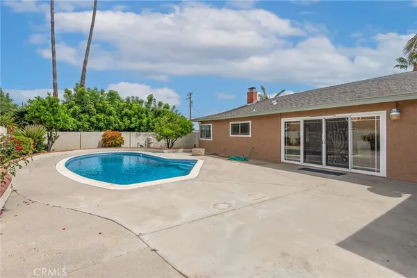 a view of a white house with a swimming pool and yard