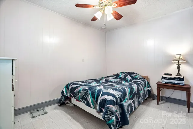 an empty room with a window and a ceiling fan