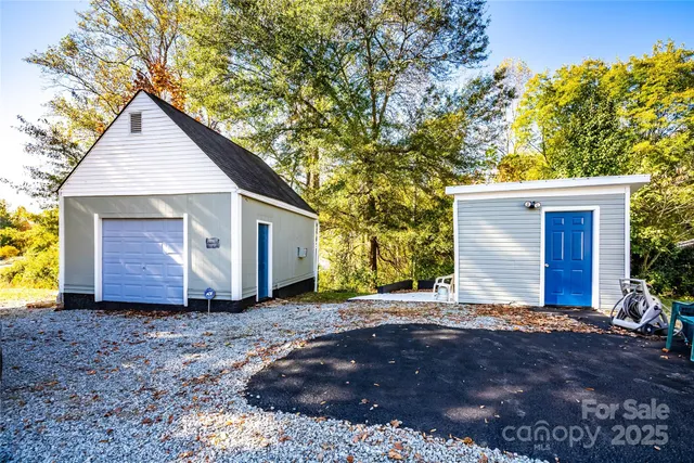 a view of a house with a yard and large tree