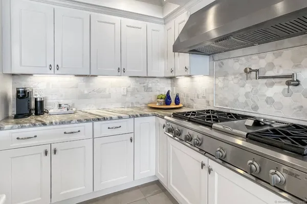 a kitchen with white cabinets and stainless steel appliances