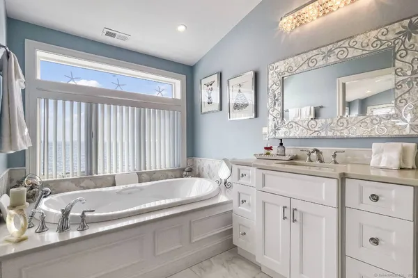a spacious bathroom with a granite countertop sink and a bathtub