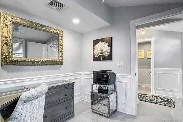 a living room with furniture and a painting on the wall