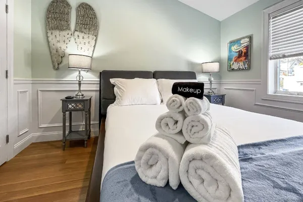 a bed with a white comforter and pillows