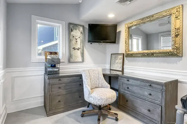 a living room with furniture and a painting on the wall