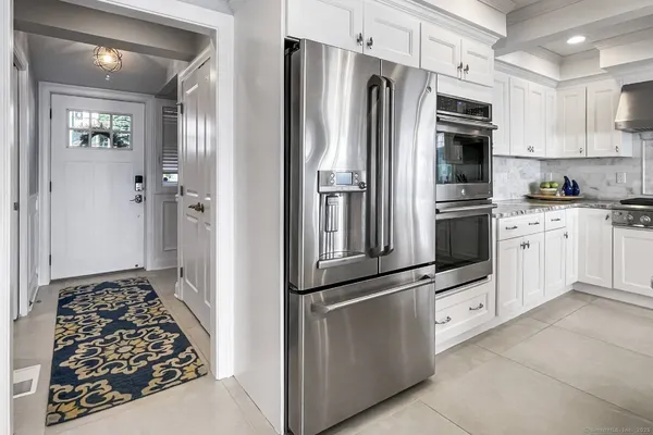 a kitchen with granite countertop a refrigerator stove and sink