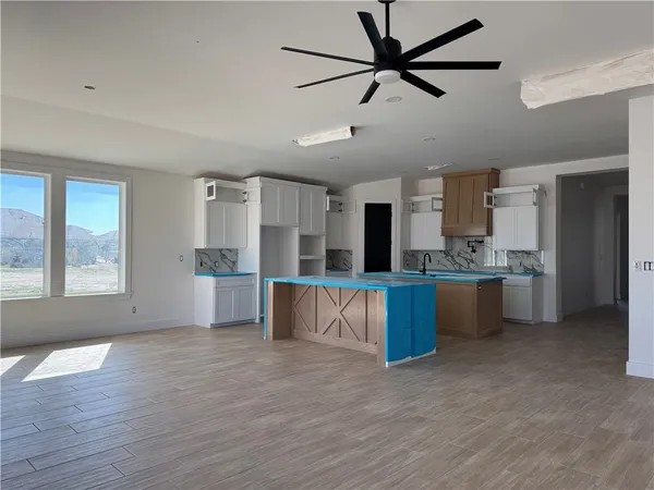 a large kitchen with stainless steel appliances kitchen island granite countertop a refrigerator a stove a sink dishwasher and a oven with wooden floor
