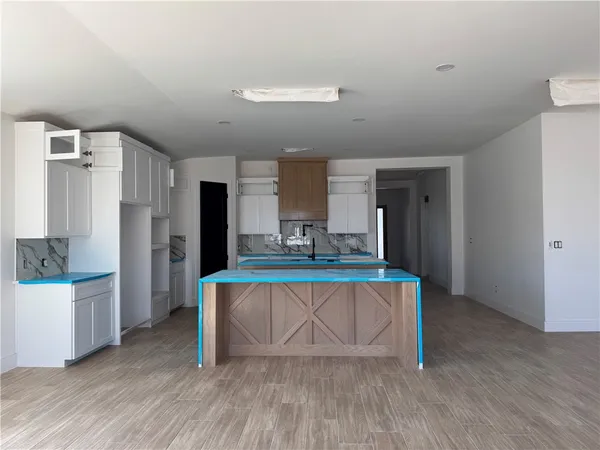 a living room with stainless steel appliances furniture a refrigerator and wooden floor