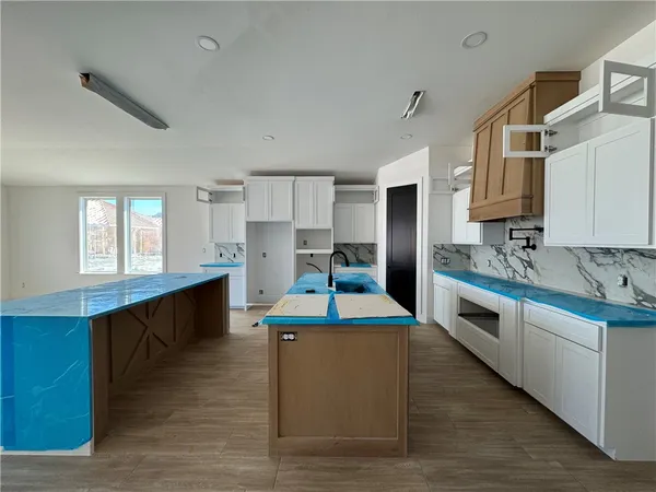 a large kitchen with stainless steel appliances kitchen island granite countertop a large counter top and stove top oven