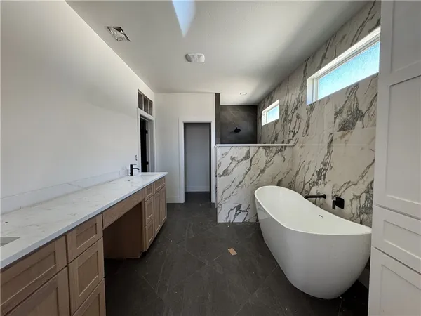 a bathroom with a white tub toilet sink and mirror