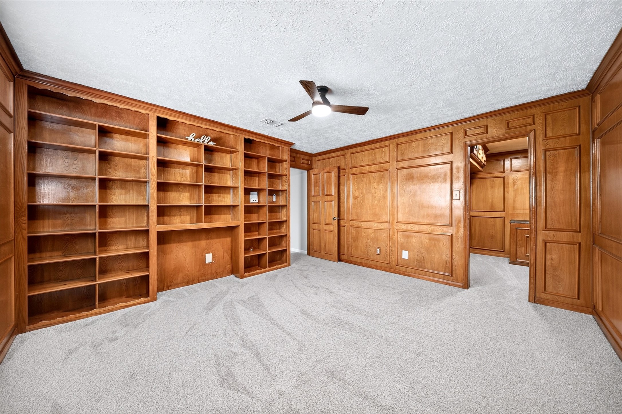 6507 Spring Leaf Drive Spring, TX 77379 - Photo 32 of 50 Fourth bedroom upstairs is a versatile space! Fully wrapped in rich wood paneling with an entire wall of custom built-in bookshelves, this room can easily serve as a magnificent home office, a cozy library, a uniquely styled nursery with a built-in toy and book storage. So many possibilities!