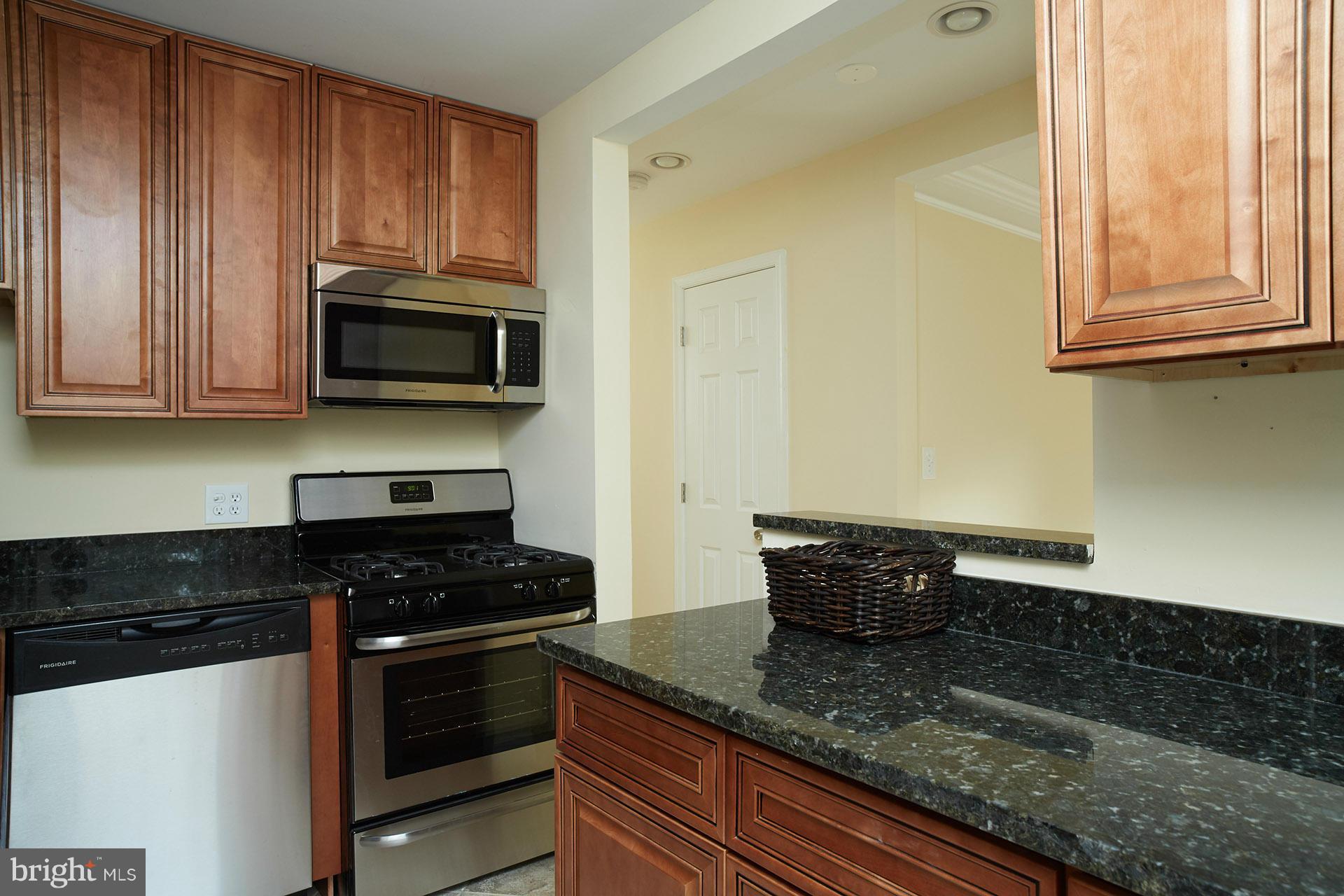 11805 Dewey Road Silver Spring, MD 20906 - Photo 6 of 30 a kitchen with stainless steel appliances granite countertop a stove a microwave and cabinets