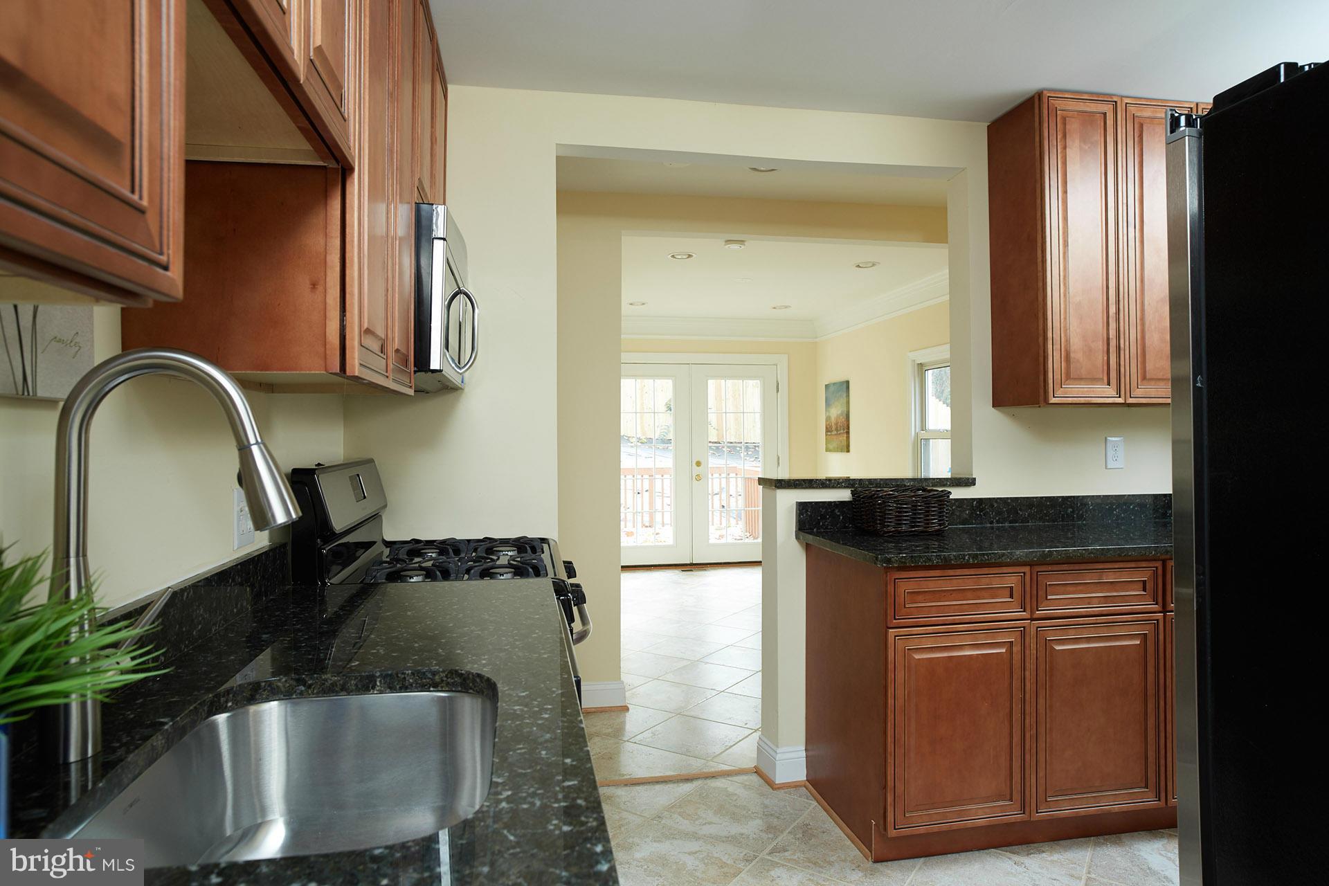 11805 Dewey Road Silver Spring, MD 20906 - Photo 7 of 30 a kitchen with granite countertop a stove and a refrigerator