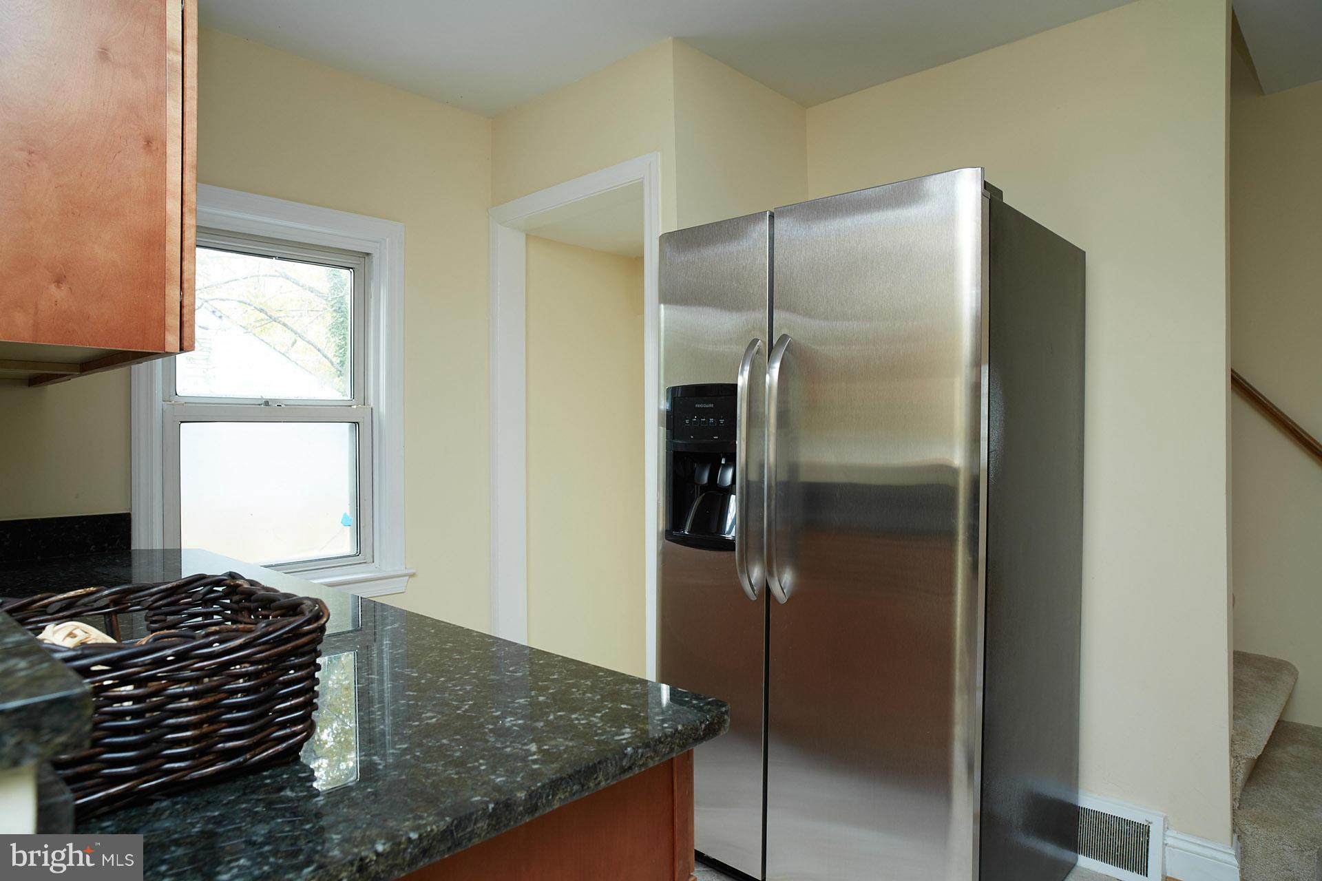 11805 Dewey Road Silver Spring, MD 20906 - Photo 8 of 30 a kitchen with a refrigerator and a stove top oven