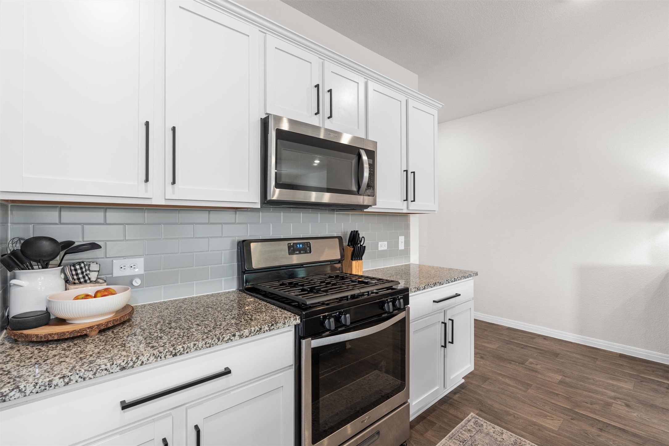 19912 Abigail Fillmore Road Manor, TX 78653 - Photo 7 of 31 A well-appointed kitchen features white cabinetry and sleek stainless steel appliances, complemented by a stylish subway tile backsplash.