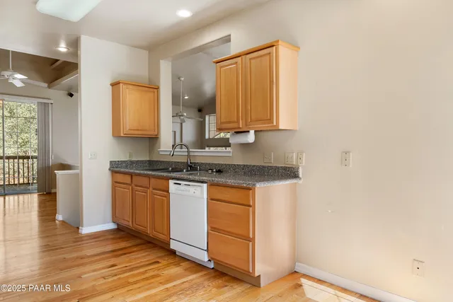 a kitchen with stainless steel appliances granite countertop a sink and a wooden cabinets