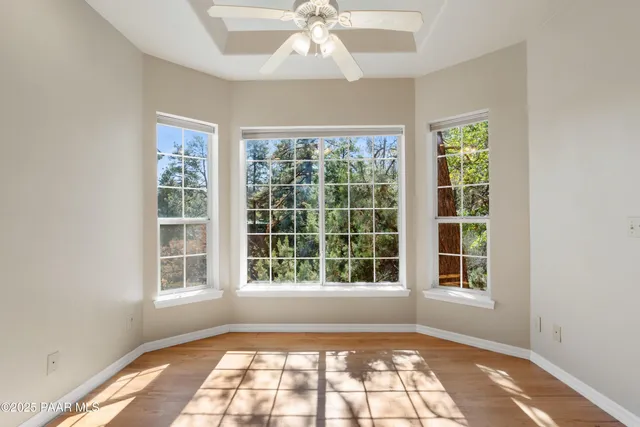 an empty room with wooden floor chandelier and window