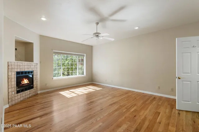 wooden floor fireplace and windows in an empty room