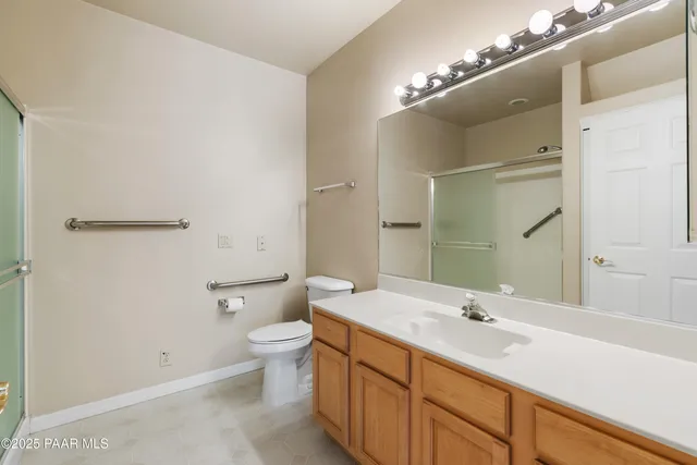 a bathroom with a double vanity sink toilet and a mirror