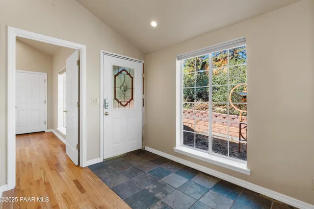 a view of a hallway with wooden floor and a kitchen