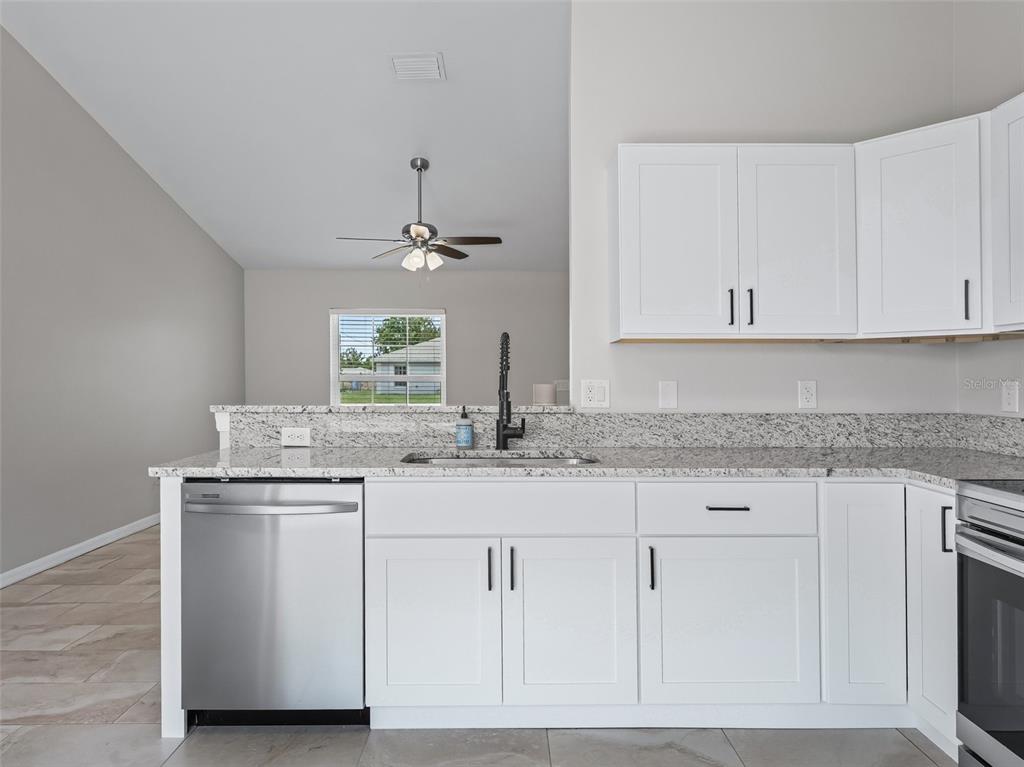 27 Juniper Loop Terrace Ocala, FL 34480 - Photo 11 of 35 a kitchen with granite countertop white cabinets and a sink