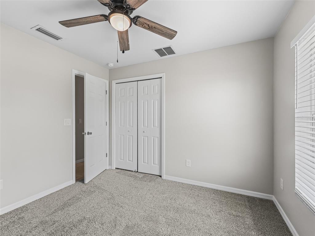 27 Juniper Loop Terrace Ocala, FL 34480 - Photo 20 of 35 an empty room with a window and a chandelier fan