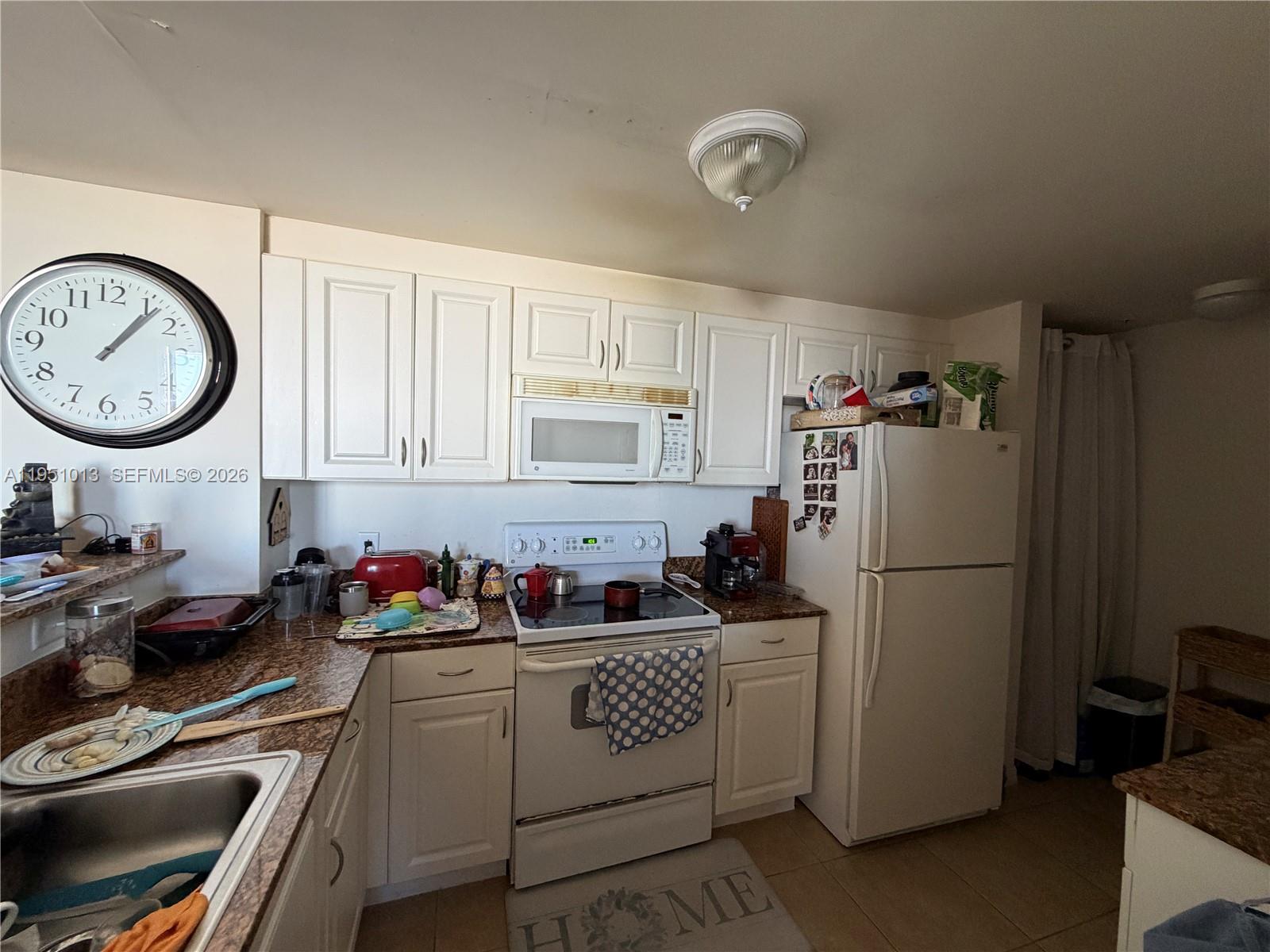 215 Southwest 42nd Avenue, Unit 803 Miami, FL 33134 - Photo 13 of 20 a kitchen with a refrigerator a stove a sink and cabinets