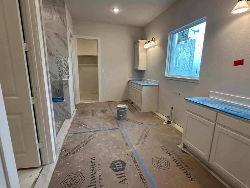 585 Brown Road Leonard, TX 75452 - Photo 16 of 29 Bathroom featuring a tiled shower enclosure with a built-in niche, white shaker-style cabinetry, and a window providing natural light