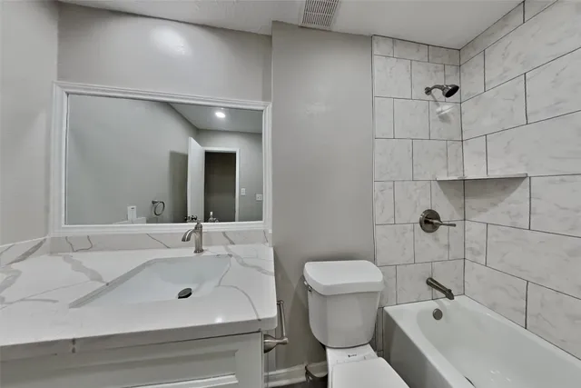 a bathroom with a sink and mirror with toilet