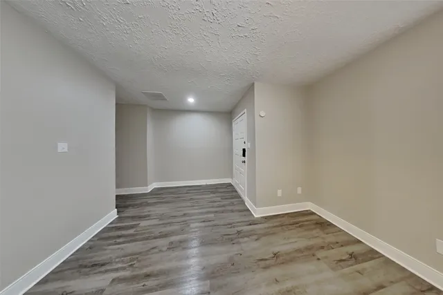 a view of an empty room and wooden floor