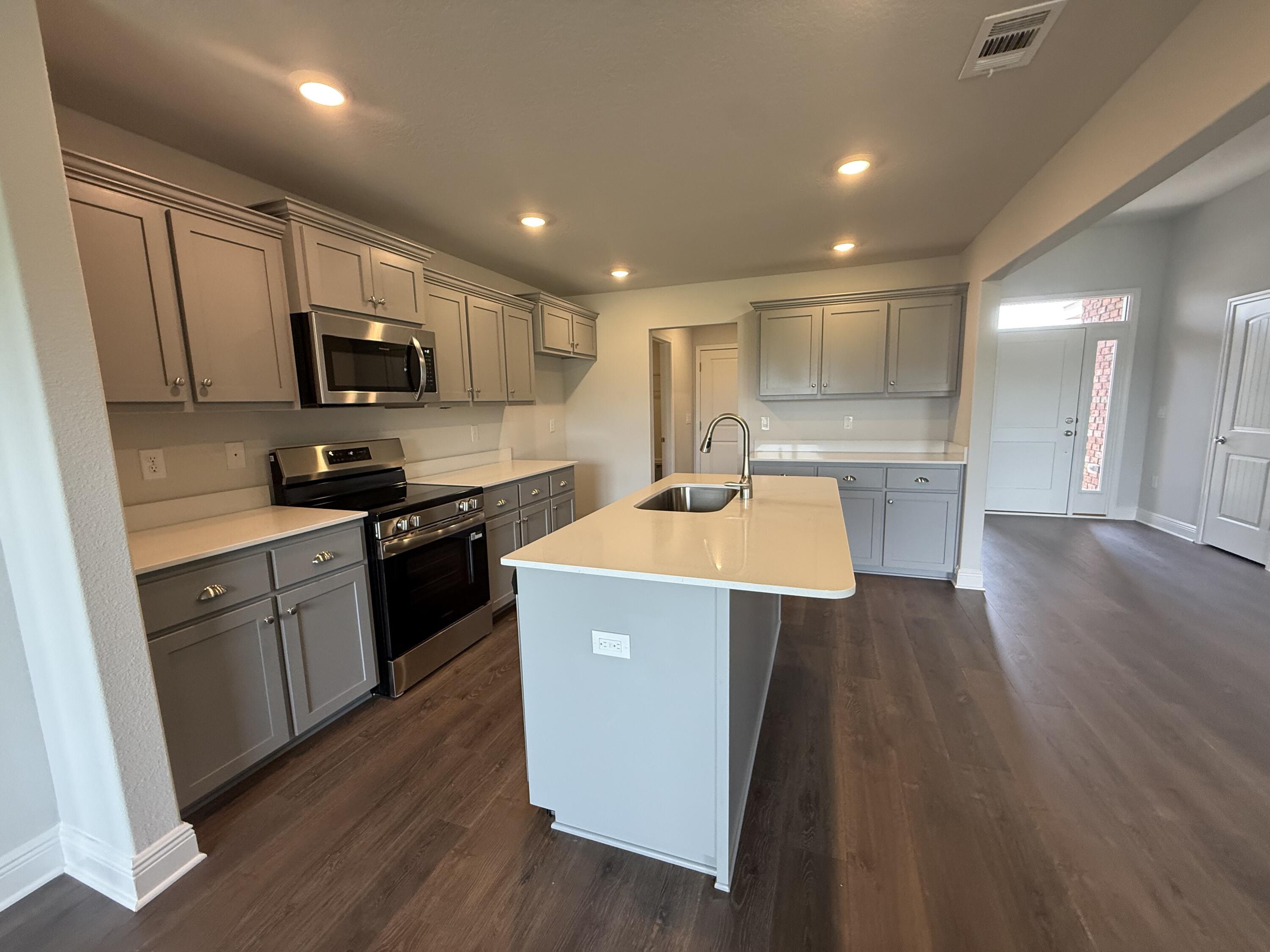 6004 Crocket Cove Crestview, FL 32539 - Photo 18 of 24 a kitchen with kitchen island a sink stainless steel appliances and cabinets