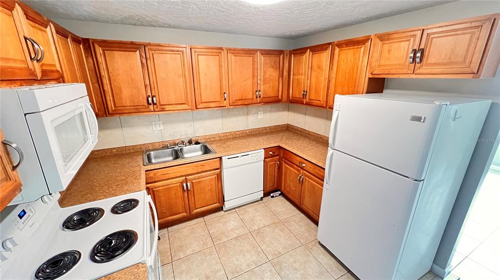 1902 Honour Road, Unit 24 Orlando, FL 32839 - Photo 5 of 25 a kitchen with a refrigerator a sink and a stove