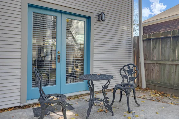 a patio with table and chairs and potted plants