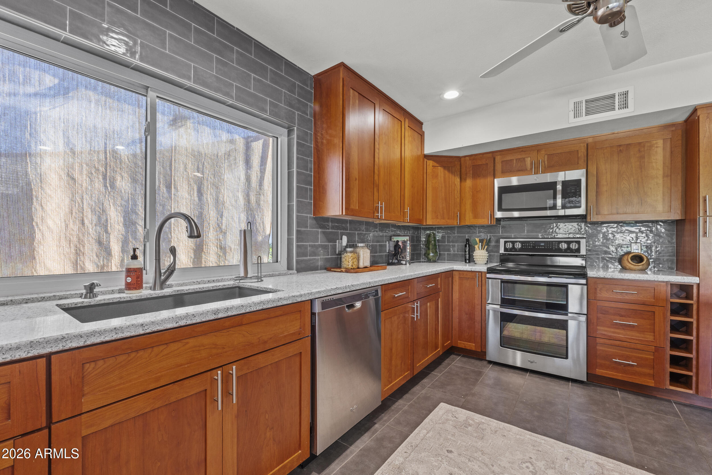 1608 East Weathervane Lane Tempe, AZ 85283 - Photo 10 of 33 a kitchen with stainless steel appliances a stove sink and microwave