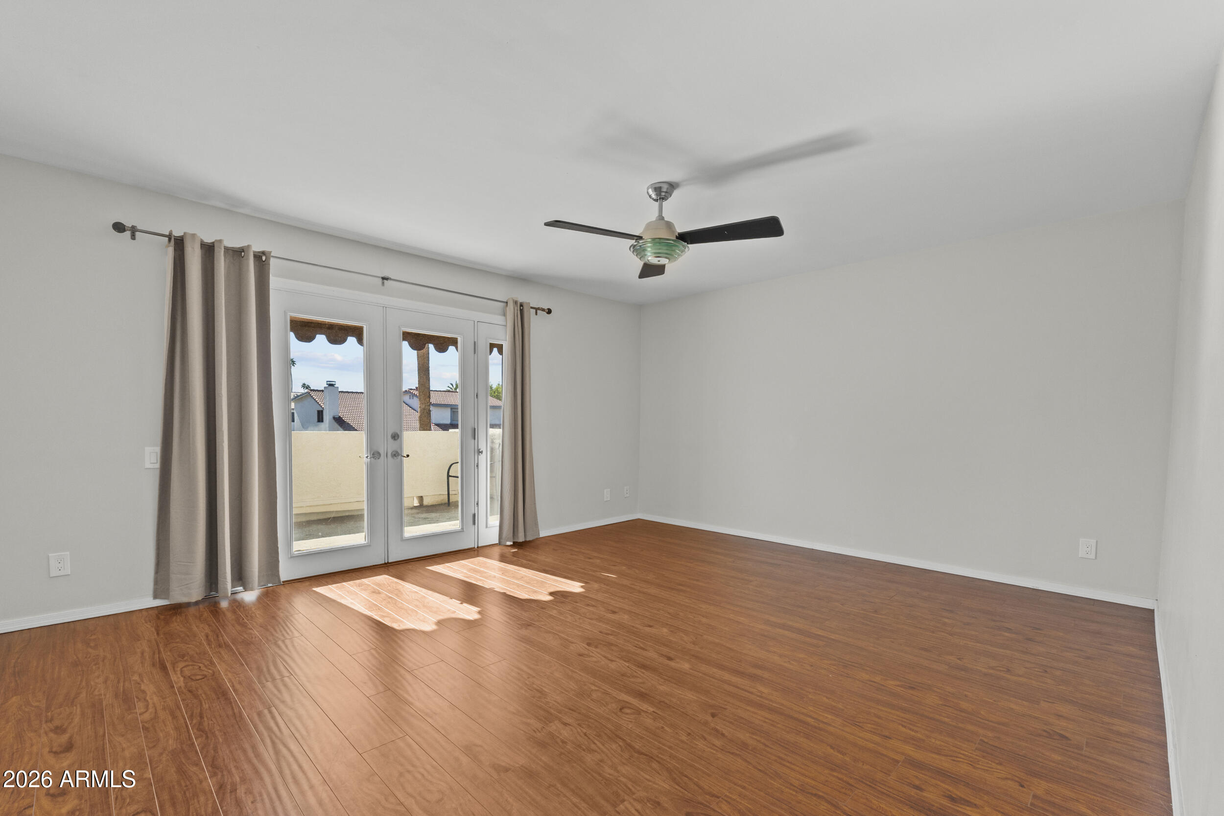 1608 East Weathervane Lane Tempe, AZ 85283 - Photo 20 of 33 a view of an empty room with wooden floor and a window