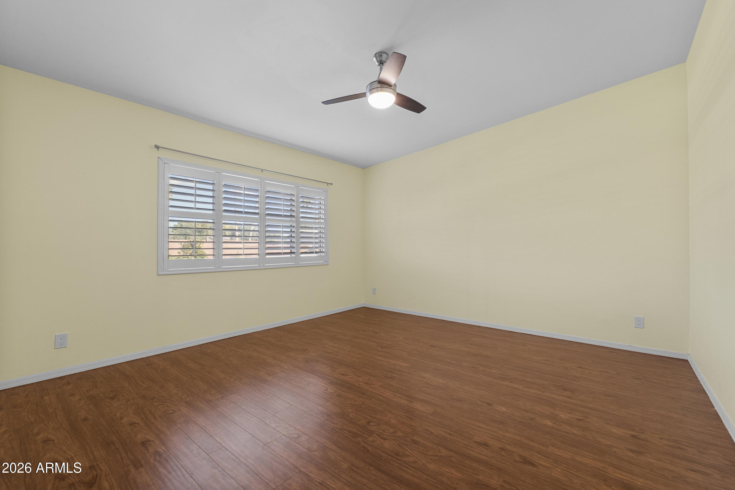 1608 East Weathervane Lane Tempe, AZ 85283 - Photo 23 of 33 an empty room with wooden floor ceiling fan and windows