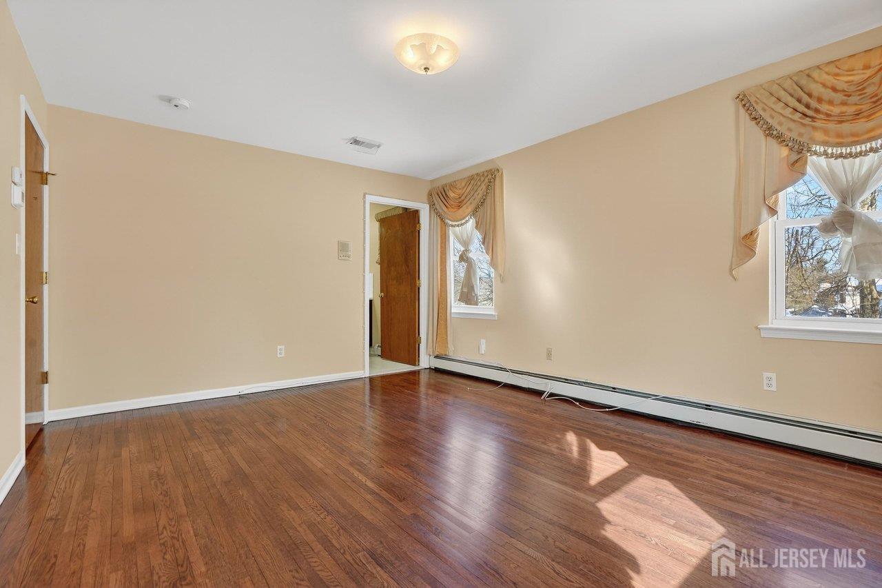 1 Wakefield Drive Edison, NJ 08820 - Photo 12 of 29 an empty room with wooden floor and windows