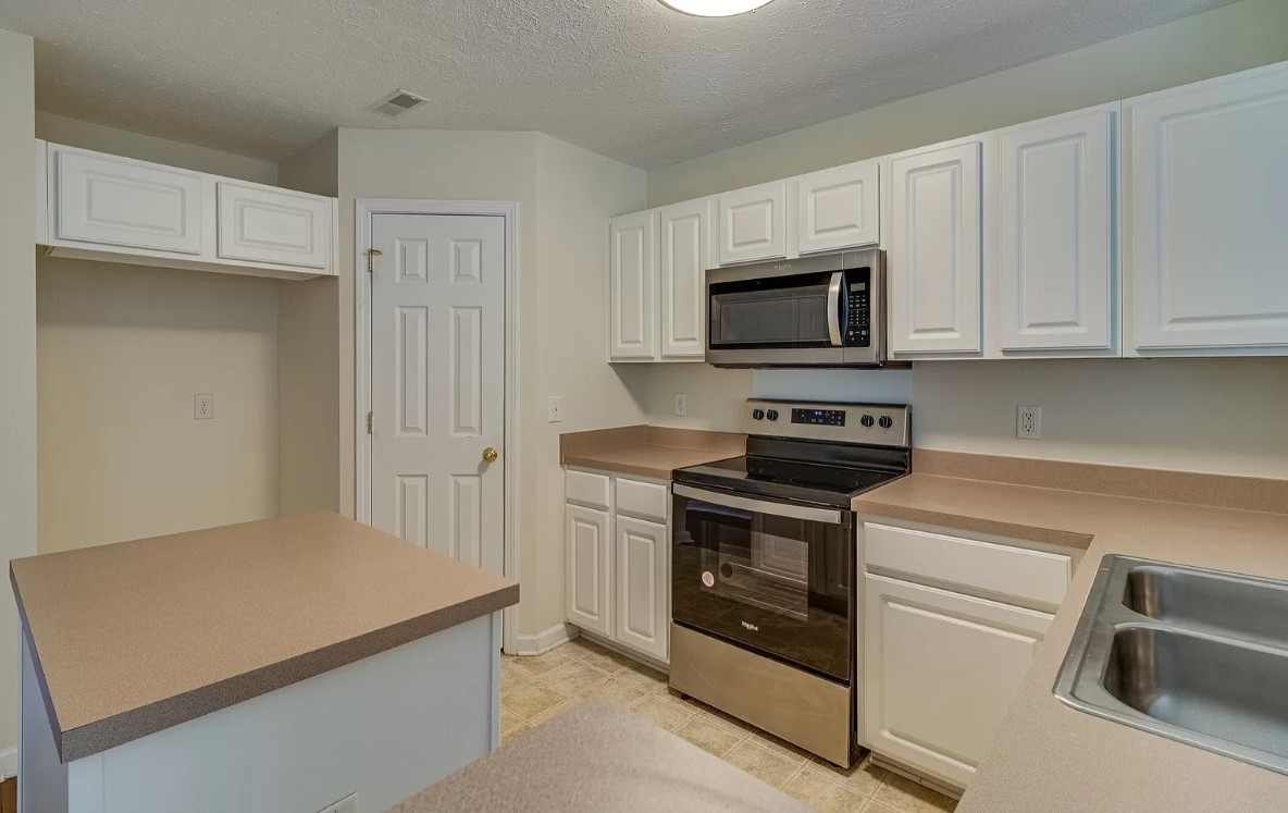 562 Flintlock Court Nashville, TN 37217 - Photo 6 of 20 a kitchen with granite countertop white cabinets and stainless steel appliances