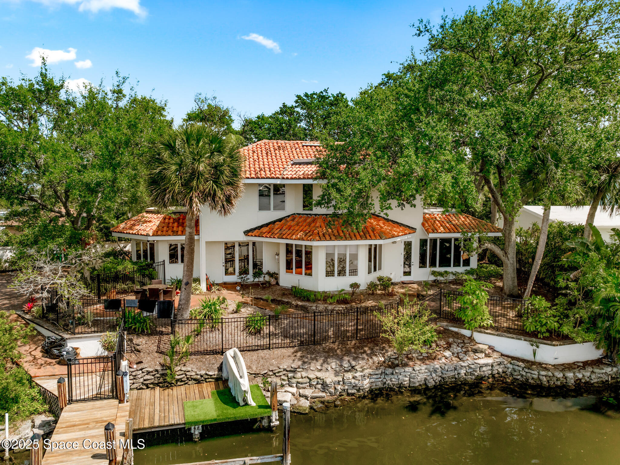 an aerial view of a house with a garden and lake view