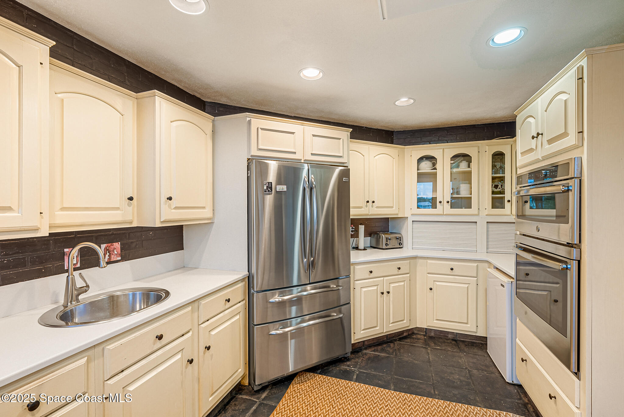 1025 Terry Drive Melbourne, FL 32935 - Photo 27 of 72 a kitchen with a refrigerator sink and cabinets