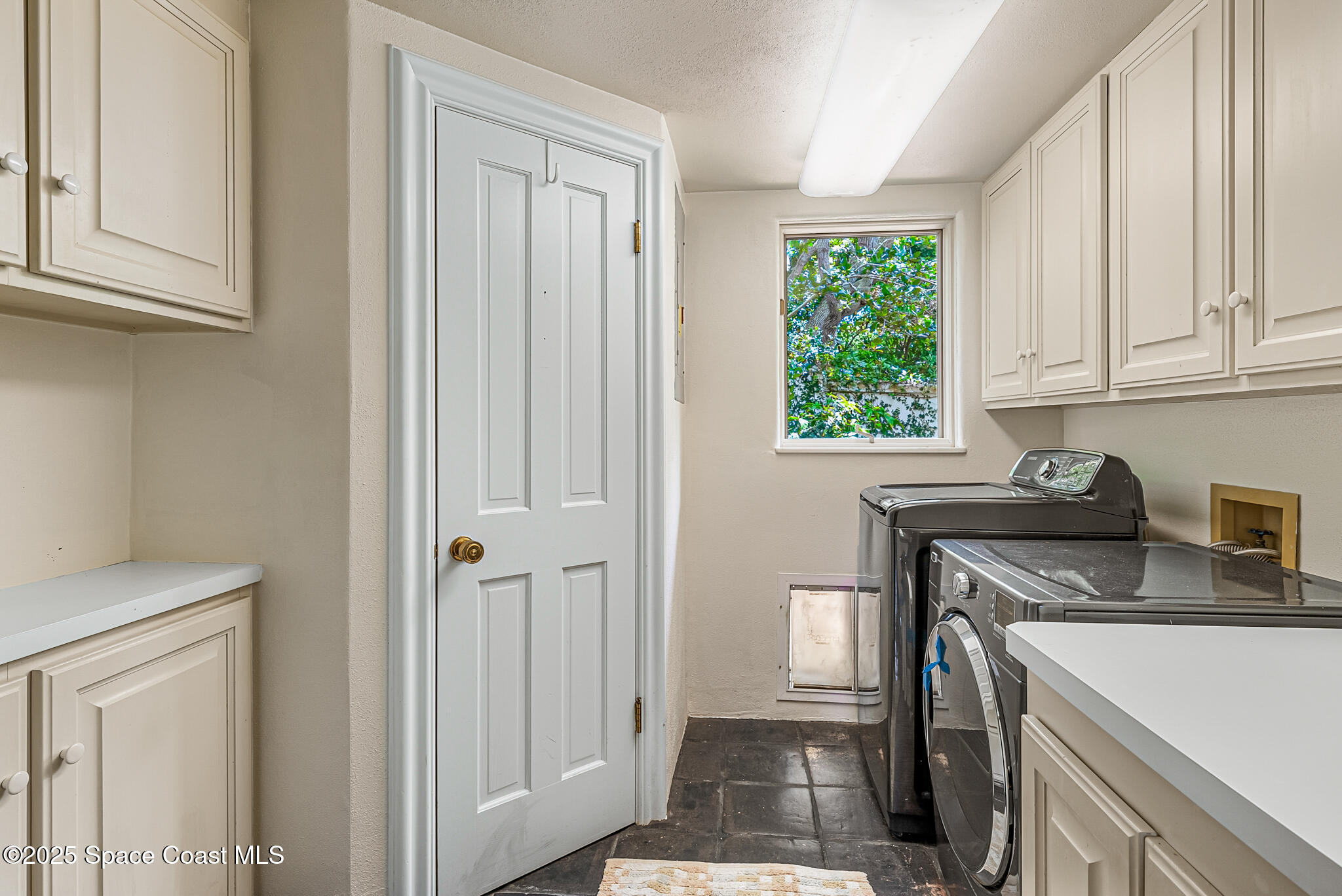 1025 Terry Drive Melbourne, FL 32935 - Photo 36 of 72 a kitchen with stainless steel appliances granite countertop white cabinets and window